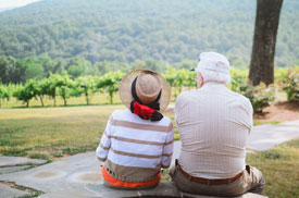 Ældre par sidder med ryggen til og kigger ud over et grønt landskab